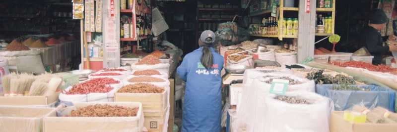 A person walks into a crowded market stall.